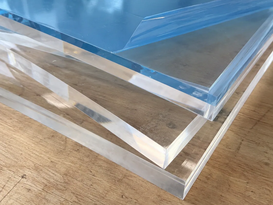 Láminas de acrílico transparente apiladas, con la película protectora encima